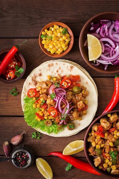 Mexican tacos with meat, corn and olives on wooden background. Top view