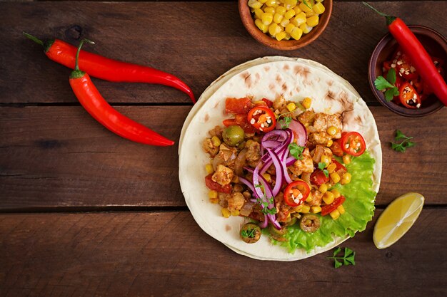 Mexican tacos with meat, corn and olives on wooden background. Top view