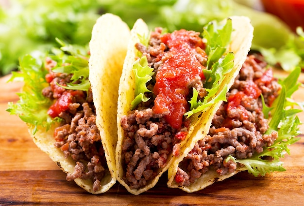 Mexican tacos with meat and salsa on a wooden table