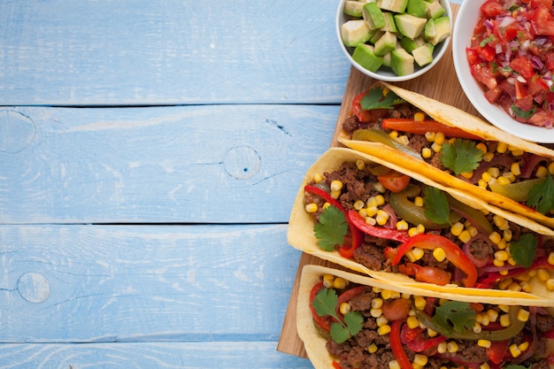 Mexican tacos with minced beef, vegetables and salsa.