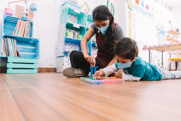 Mexican teacher and child with masks at school after covid-19 quarantine