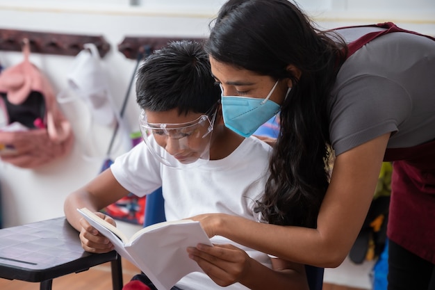 コロナウイルスのパンデミック後、学校に戻ってフェイスマスクを身に着けているメキシコの教師と学生