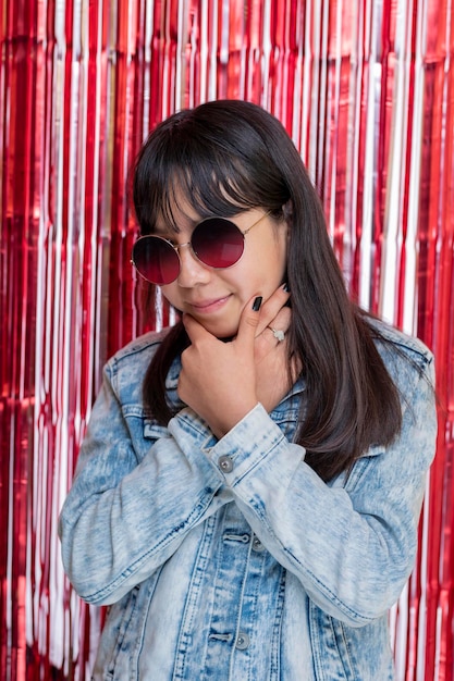 Mexican teenager at party with sunglasses smiling looking at the camera