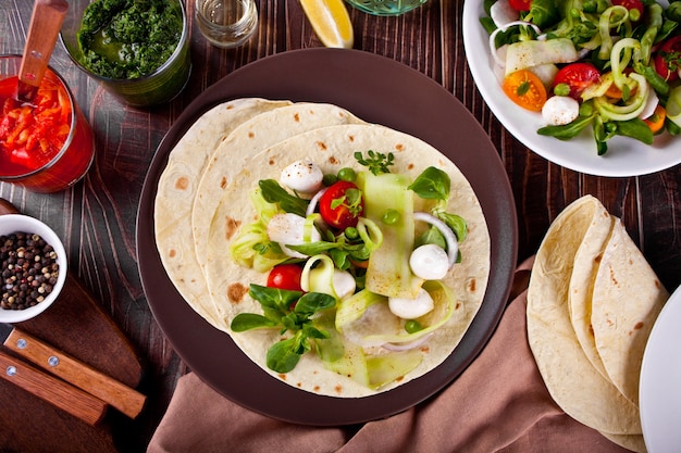 Mexican vegan tortilla wrap with vegetables on the dinner table