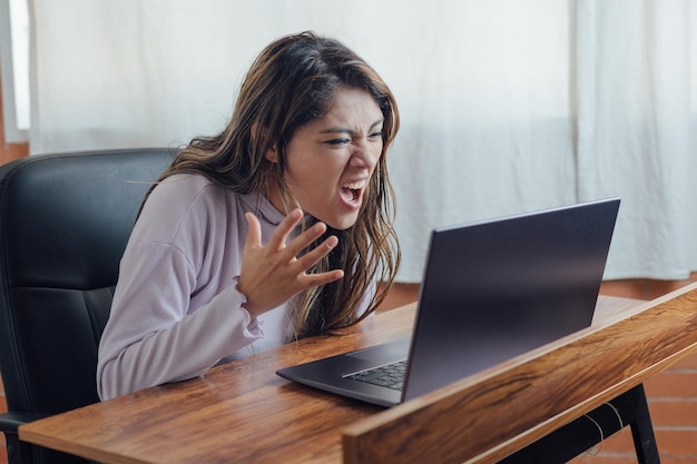 Mexican woman with home office yells at computer screen