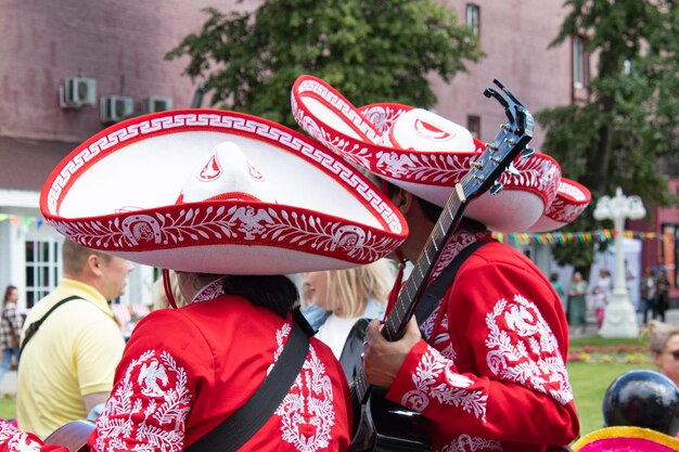 Photo mexicans in traditional costumes play musical instruments in the park