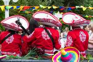 Photo mexicans in traditional costumes play musical instruments in the park