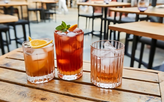 Mezcal negroni en spritz cocktails alcoholische drank op basis van tafel met ijsblokjes buiten geserveerd cocktail met sinaasappelschijf en stro op houten tafel van trottoircafé in Italië