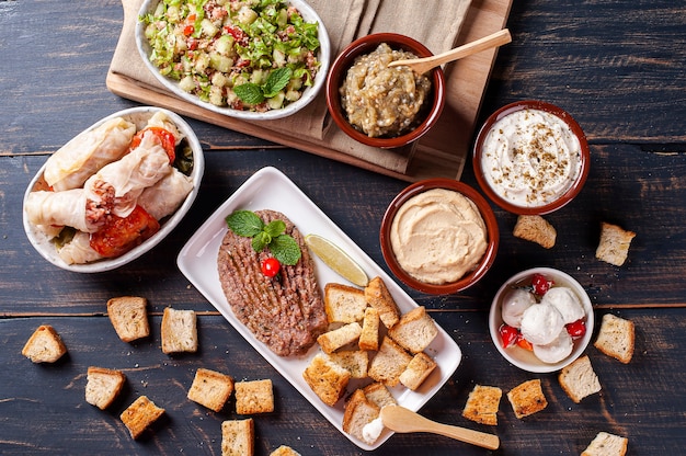 Meze is an oriental set of appetizers served in small bowls with babaganush, curd, hummus and kibbeh