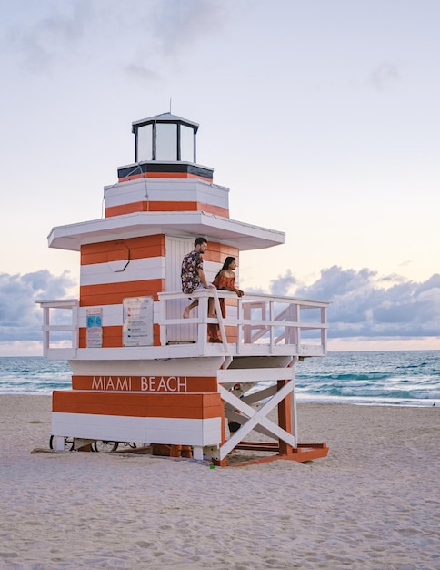 Miami beach couple on the beach at miami beach life guard hut miami beach florida