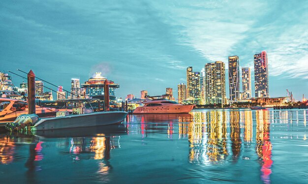 Miami city skyline panorama with urban skyscrapers over sea with reflection.