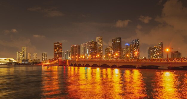 Miami, Florida stadsgezicht skyline op Biscayne Bay. Panorama in de schemering met stedelijke wolkenkrabbers en brug over zee met reflectie.