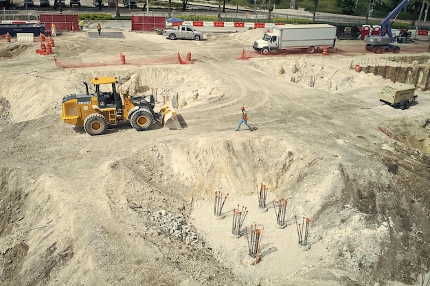 Miami usa october 30 2015 workers and machinery on construction
pit building site works on sunny outdoor construction and building
activity development and engineering concept