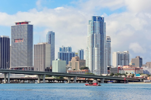 Miami wolkenkrabbers met brug over zee in de dag.