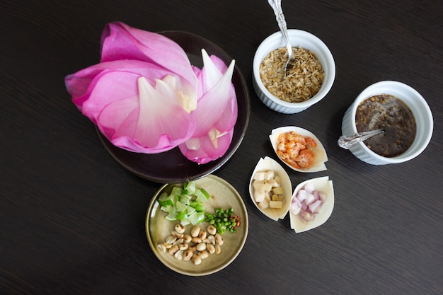 Miang Kham Bua Luang, 전통 태국 스낵 연꽃 꽃잎은 설탕 소스와 견과류, 생강, 말린 새우, 코코넛 플레이크로 감쌉니다.