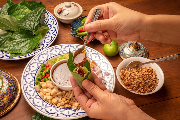 Miang Kham 또는 야생 빈랑 잎 달콤한 디핑 소스와 함께 재료를 포장 아시아 전채 음식