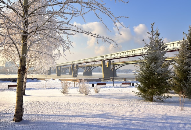 Michael's embankment in winter. Metro bridge bridge over the Ob river leads to a mountain area