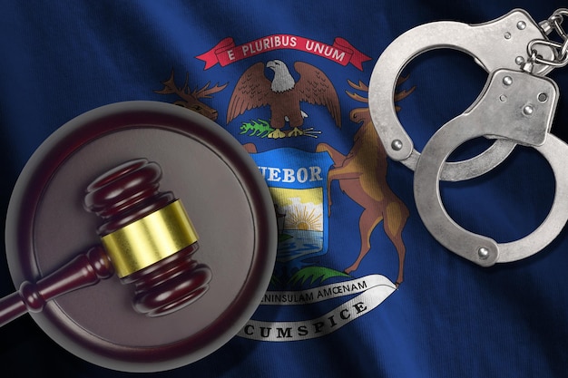 Photo michigan us state flag with judge mallet and handcuffs in dark room concept of criminal and punishme