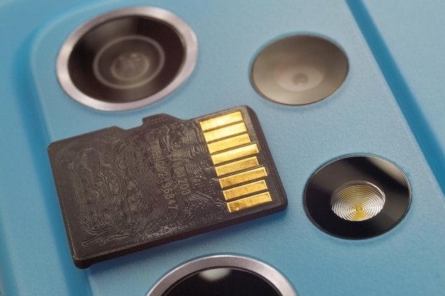 Micro sd card lies on the block of smartphone cameras closeup