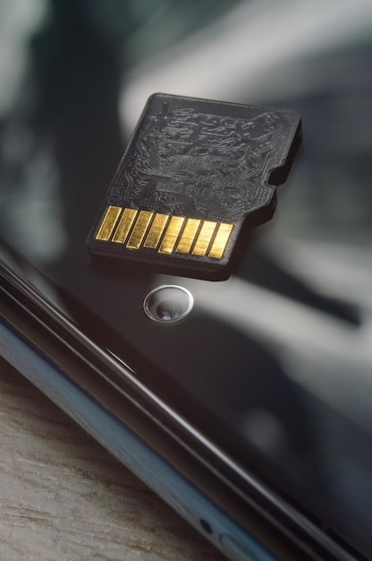 Micro sd card lies on the smartphone screen closeup