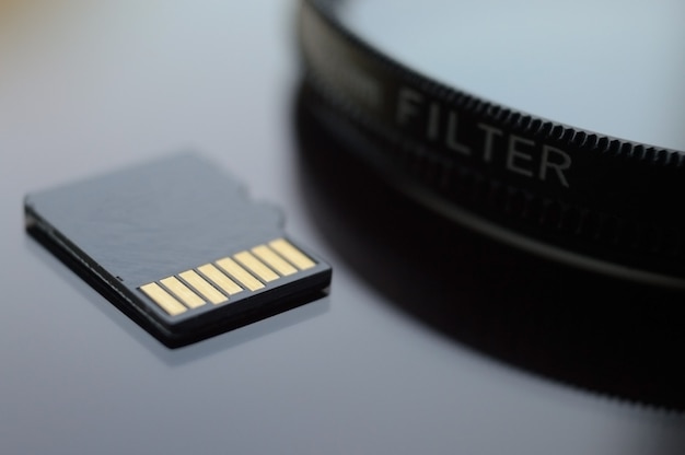 写真やビデオ技術で使用するためのマイクロSDカード。 microsdはレンズフィルターの上にあります。閉じる。