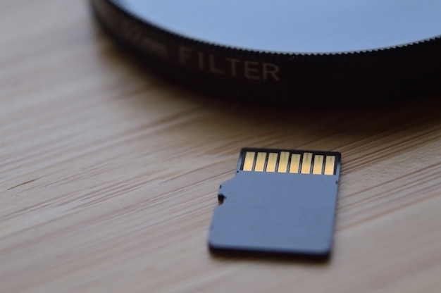 Photo micro sd card for use in photo and video technology. micro sd lies on the lens filter. close-up.