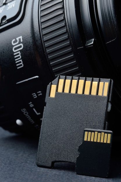 Photo micro sd card with adapter on the background of a replaceable lens for a digital camera.
