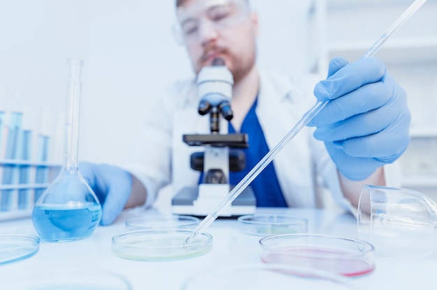 Microbiologist looks at a colony of viruses in laboratory blood test concept