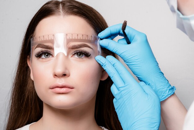 Microblading nel salone di bellezza. bella ragazza sulla procedura cosmetica per il trattamento delle sopracciglia. microelaborazione del sopracciglio.