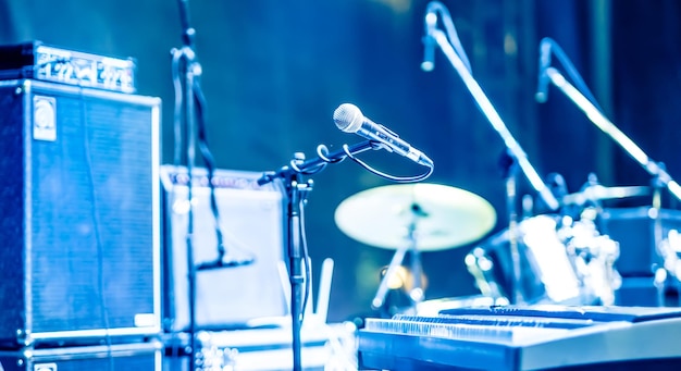 Microfoon en synthesizer op concertpodium met onschadelijk gemaakte bokeh lichten blauwe kleur achtergrond