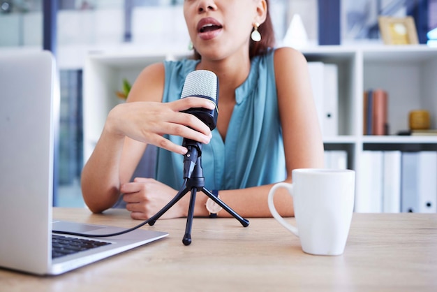 Microfoonbeïnvloeder en radio met een vrouwelijke presentator die een laptop gebruikt om live uit te zenden terwijl ze streamt in haar thuiskantoor Podcastnieuws en netwerk met een vrouwelijke freelancer die aan een bureau zit
