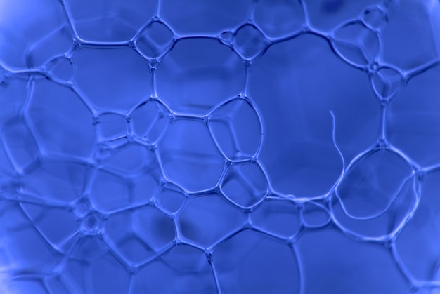 Micrograph of foamy chemical fluid. The chain of compounds of microparticles background