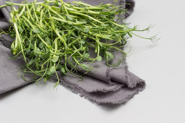 Microgreen pea sprouts on grey napkin