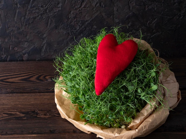 Microgreens in a kraft bag with a red heart symbolizing health and life an ecofriendly food supplement for proper nutrition and improving the quality of life