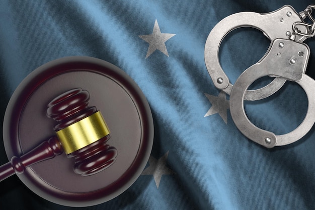 Photo micronesia flag with judge mallet and handcuffs in dark room concept of criminal and punishment background for judgement topics