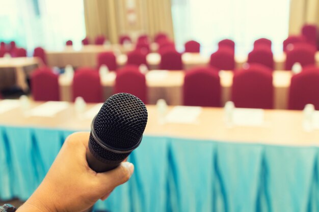 Microphone over the Abstract blurred photo of conference hall or seminar room with attendee backgrou