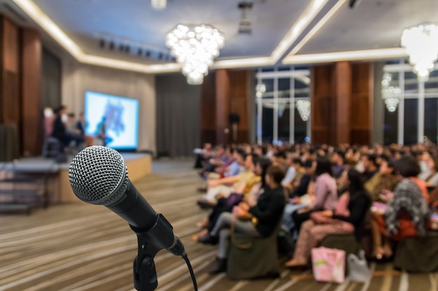 Microphone over the Abstract blurred photo of conference hall 