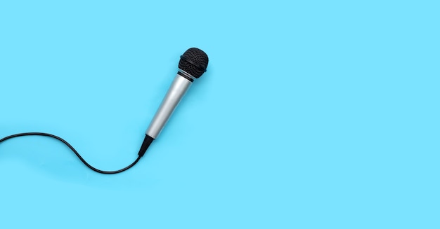 Microphone on blue background. Top view