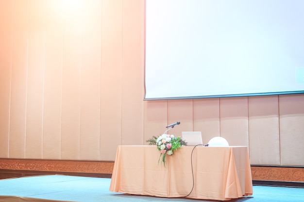 Microphone close up shot in seminar or meeting room with people in blur focus