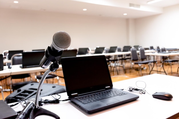 Microphone and laptop on table in seminar room