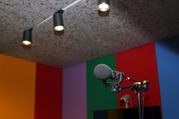 A microphone in the recording studio on the top a lights spot down background with copy space