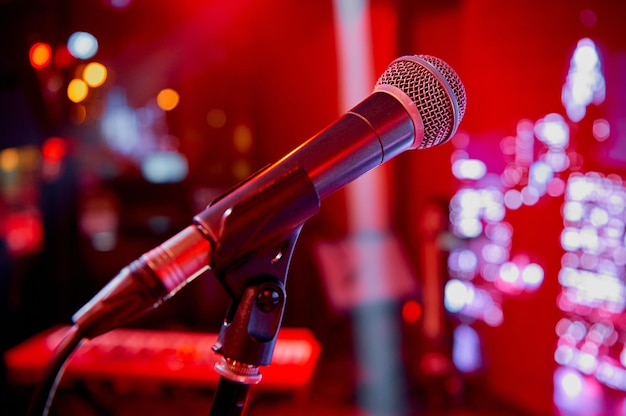 Microphone on the stage in the bar of the cafe restaurant with red colorful lighting. High quality photo