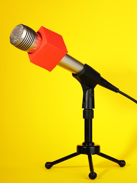 Photo microphone on stand on yellow background