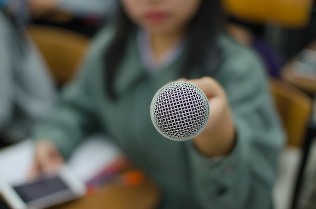 Photo microphone with blurred background of a woman holding it