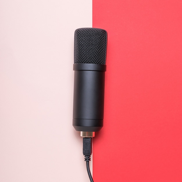 Микрофон с подключенным проводом на красной и розовой поверхности