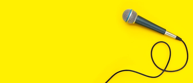 Microphone on yellow background. Top view