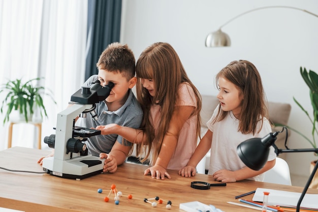 Microscoop gebruiken kinderen hebben overdag samen plezier in de huiskamer