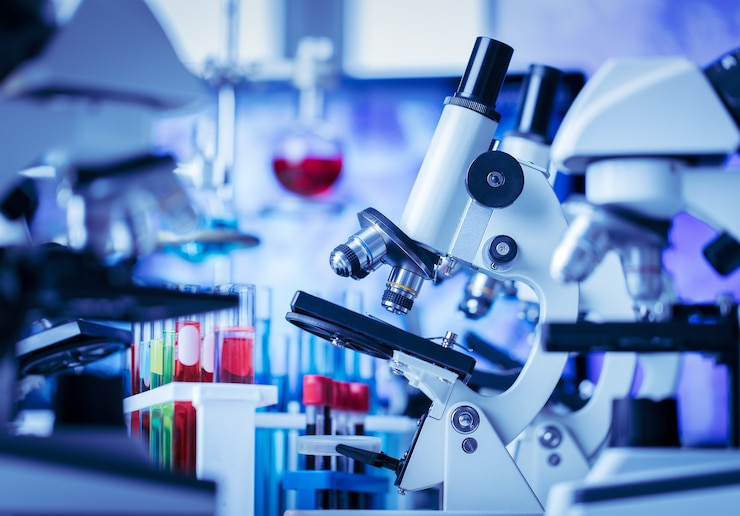 Foto microscoop in en laboratorium- en reageerbuisapparatuur in laboratoriumblauwe lichten, wetenschap en experimentconcept.