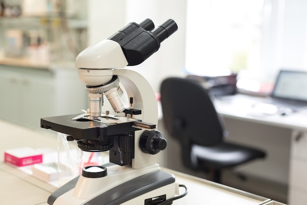 Microscope in the laboratory on table with computer.