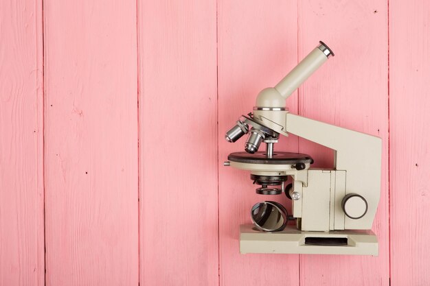 Microscopio su tavola di legno rosa